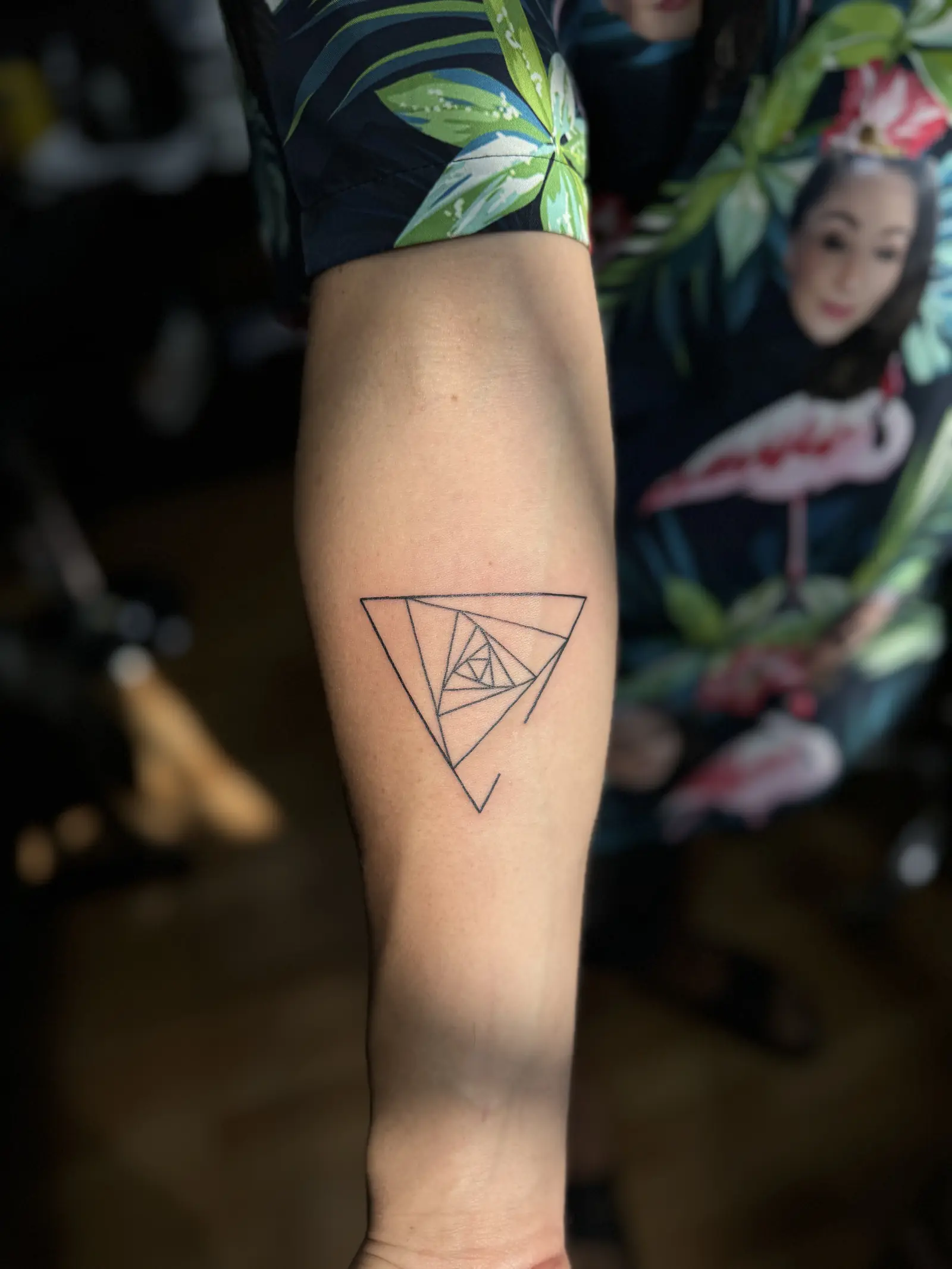 Tatuaje geométrico de un triángulo en espiral en el antebrazo, hecho en Cartagena