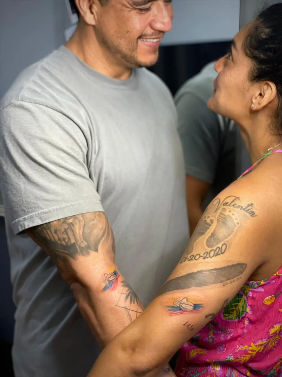 Tatuajes a color en los brazos de una pareja
