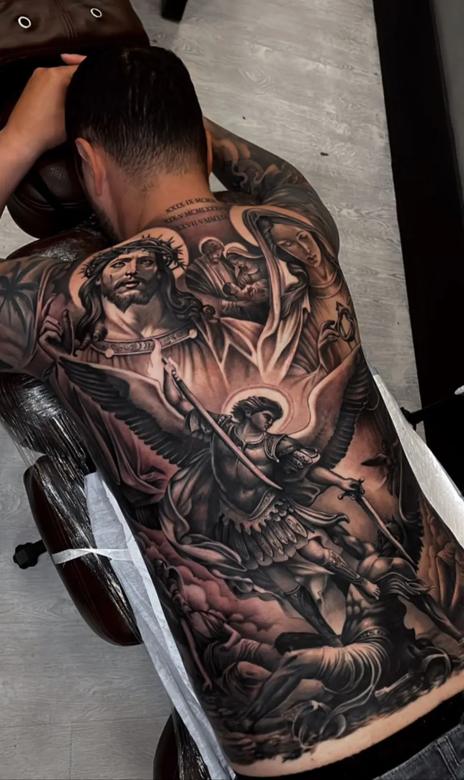 Gran tatuaje religioso en blanco y negro en la espalda, con Jesús y el arcángel Miguel, hecho en Cartagena