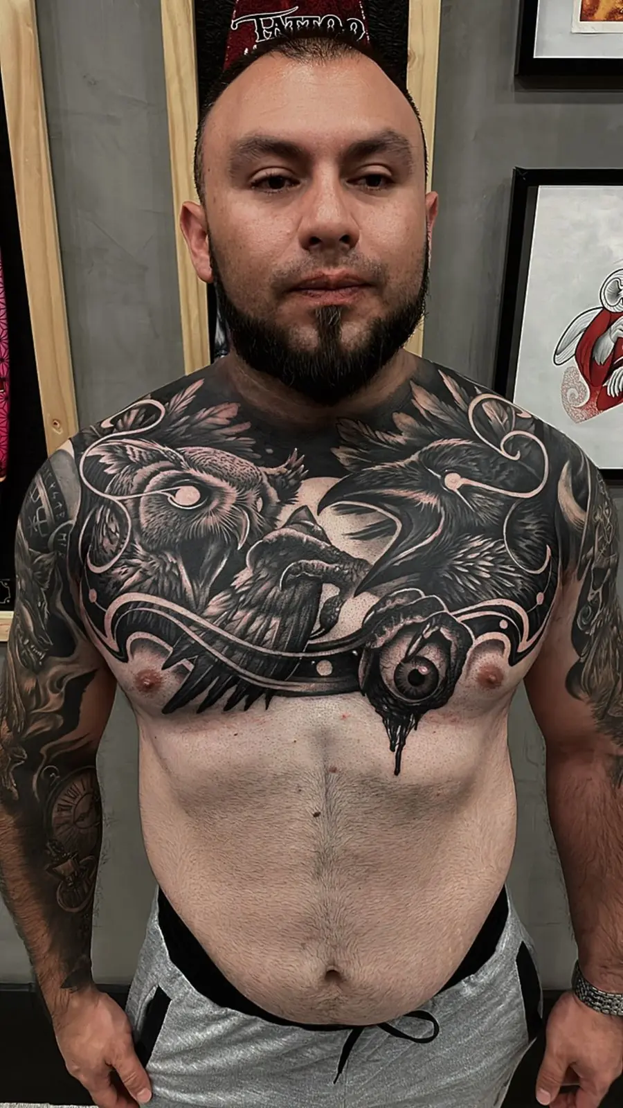 Tatuaje en blanco y negro en el pecho con cuervos y un ojo, hecho en Cartagena