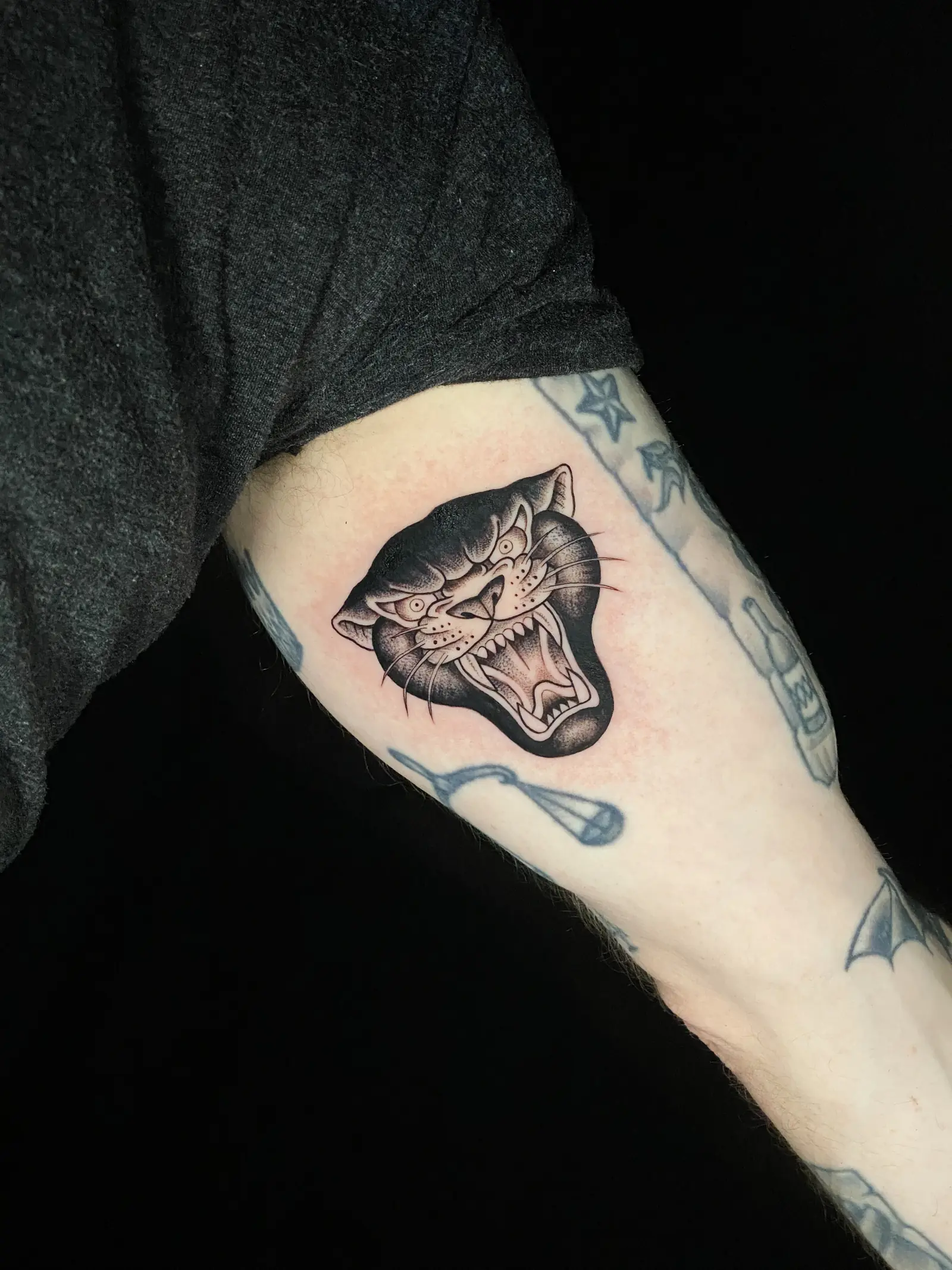 Tatuaje tradicional de la cabeza de una pantera negra en el brazo, hecho en Cartagena